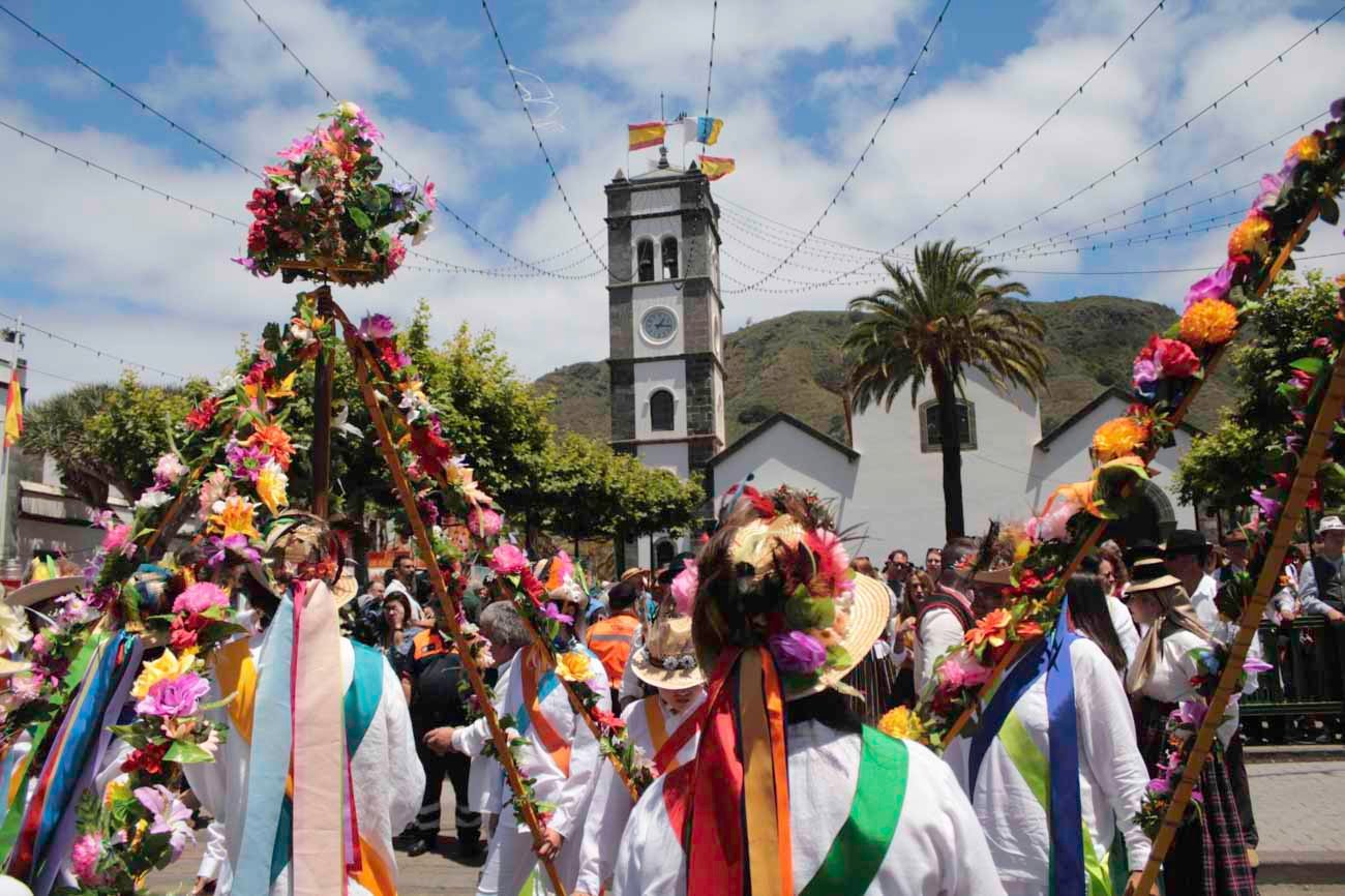 Grupo de personas bailando con vestimenta canaria típica y tradicional durante una romería en Tenerife, con faldas de colores y trajes populares en plena celebración.